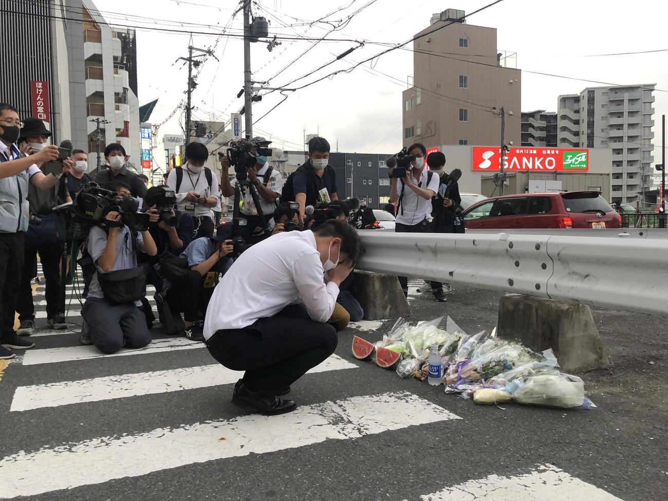安倍元首相が襲撃された現場に花を手向ける男性（撮影・益子浩一）