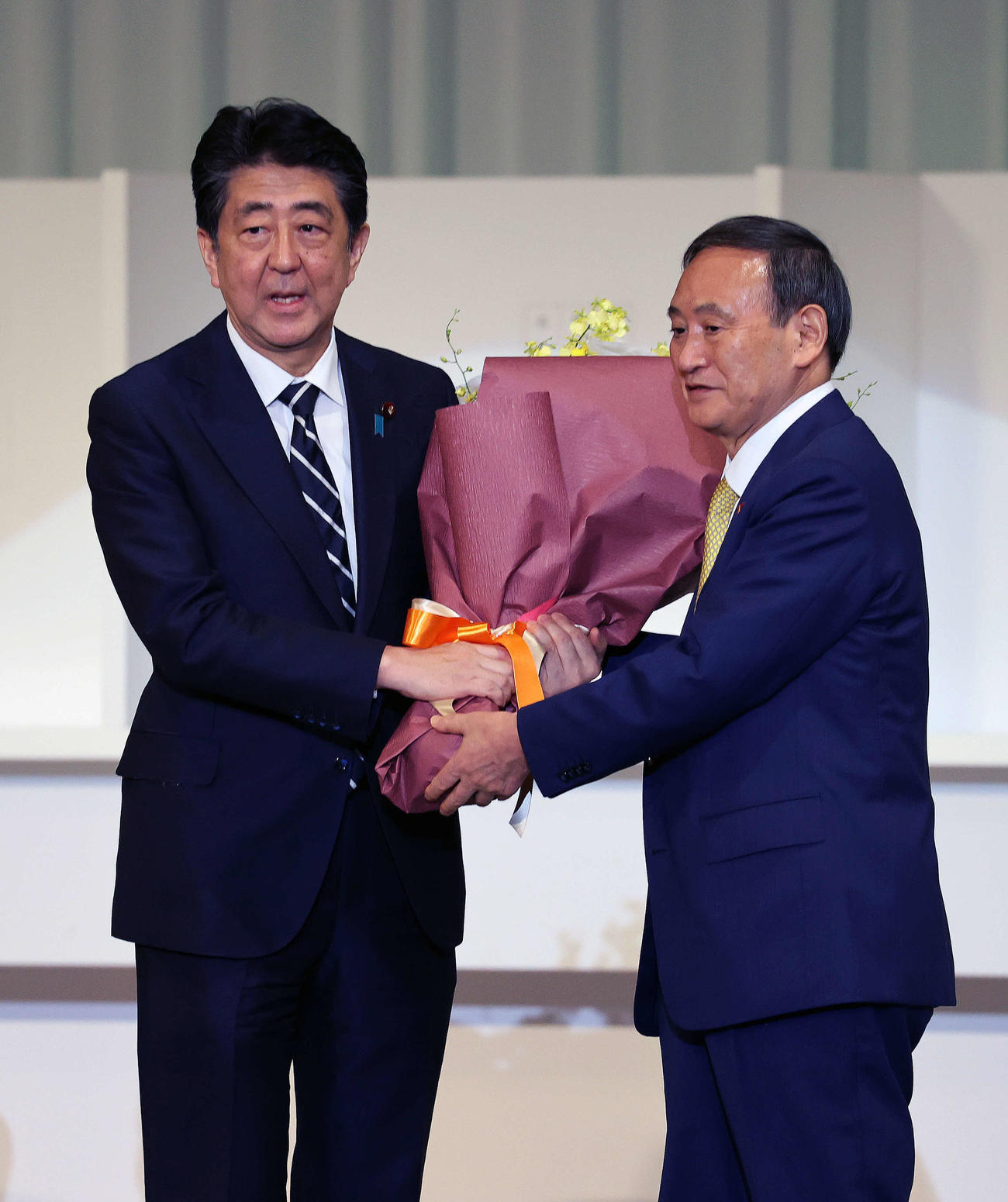 自民党総裁選投開票　第26代自民党新総裁に就任した菅義偉官房長官（右）は前総裁の安倍晋三首相に花束を贈呈する（2020年9月14日撮影）