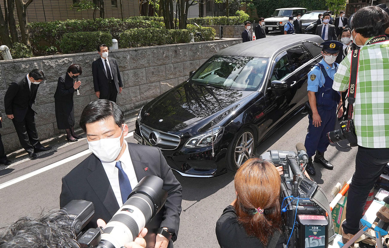 頭を下げる福田総務会長（左端）、手を合わせる高市政調会長（左から2人目）を前に自宅マンションに入る安倍氏の遺体を乗せたとみられる車両。助手席には昭恵夫人が座っていた（撮影・菅敏）