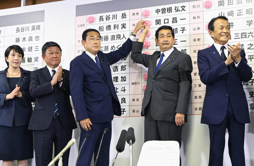 開票センターで当確者の名前に花を付ける自民党総裁の岸田首相（中央）
