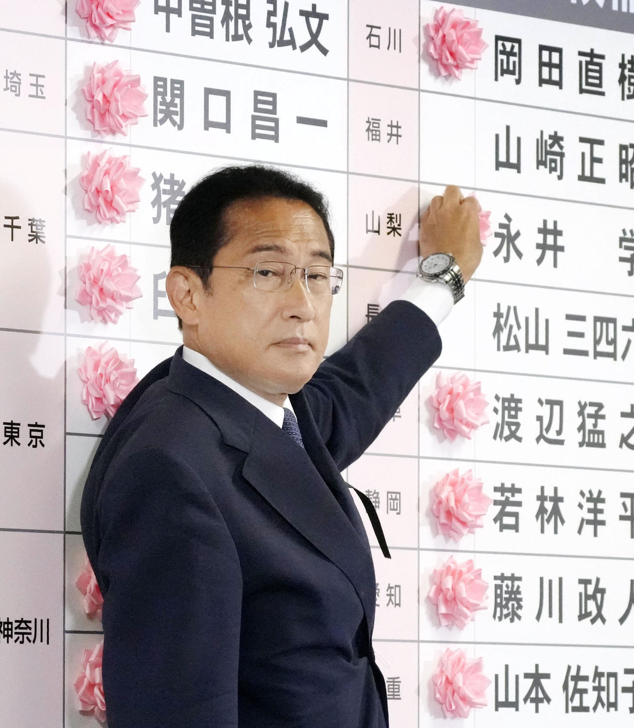 開票センターで当確者の名前に花を付ける自民党総裁の岸田首相（共同）