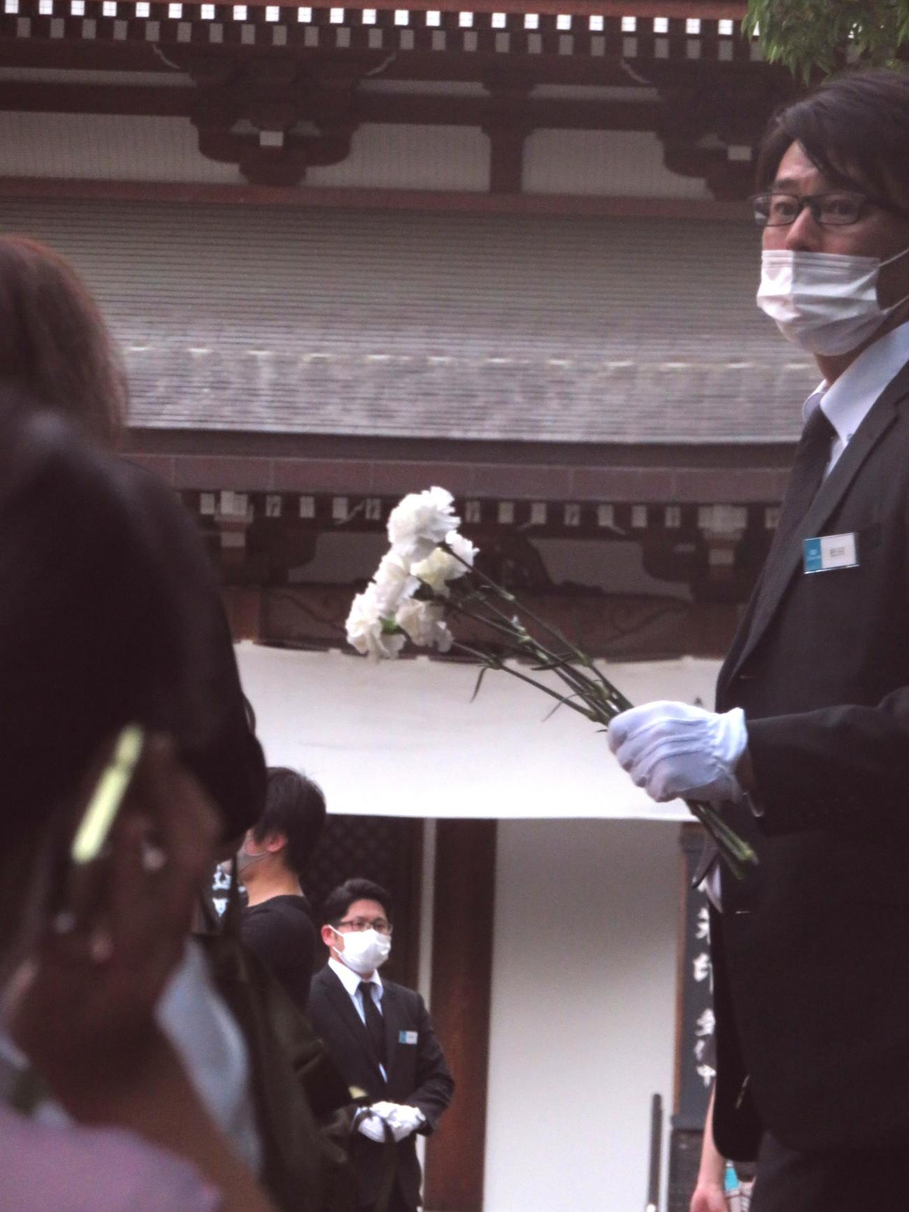 一般の献花台前では白い菊1輪が並んだすべての人に配布された（撮影・寺沢卓）