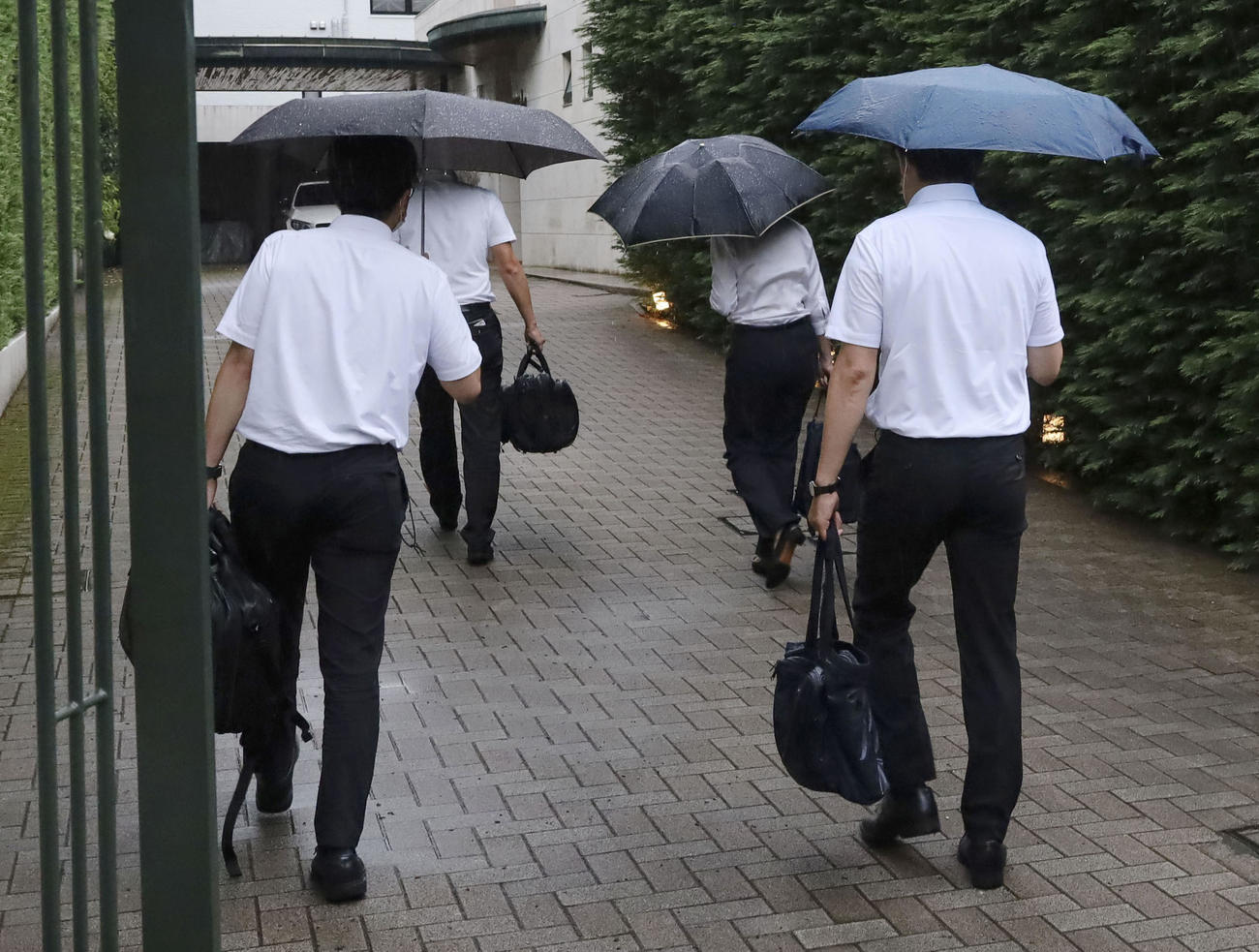 家宅捜索のため、東京五輪・パラリンピック組織委の高橋治之元理事の自宅に向かう東京地検の係官ら（共同）