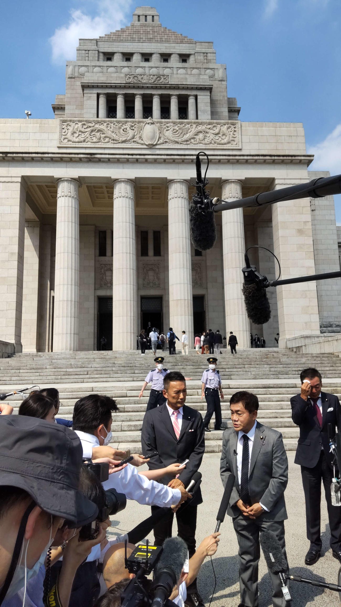 れいわ新選組の山本太郎代表と水道橋博士氏は国会議事堂の前で報道陣からの質問にこたえた（撮影・寺沢卓）