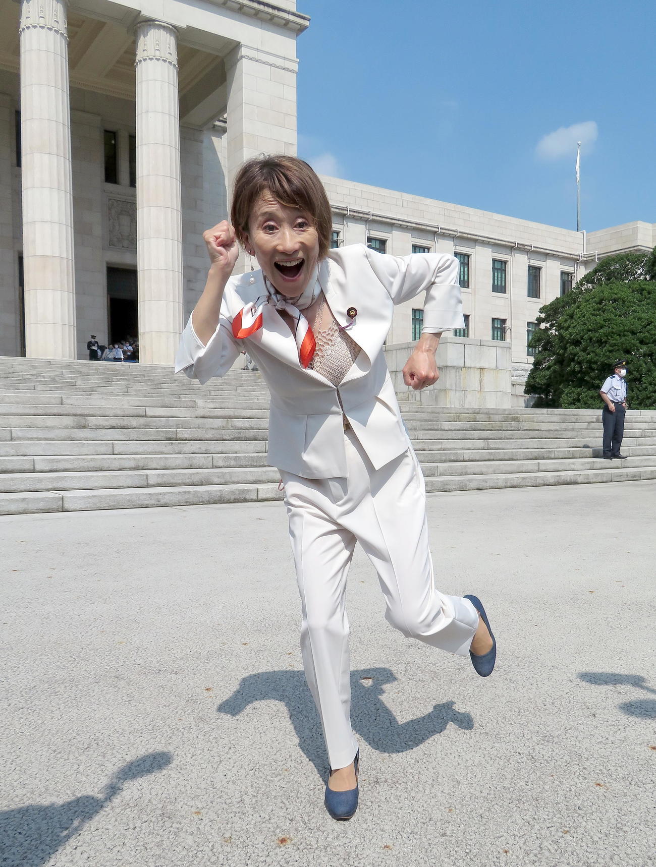 夫からプレゼントされたスカーフを巻いてランニングポーズで初登院する日本維新の会の松野明美議員（撮影・鎌田直秀）
