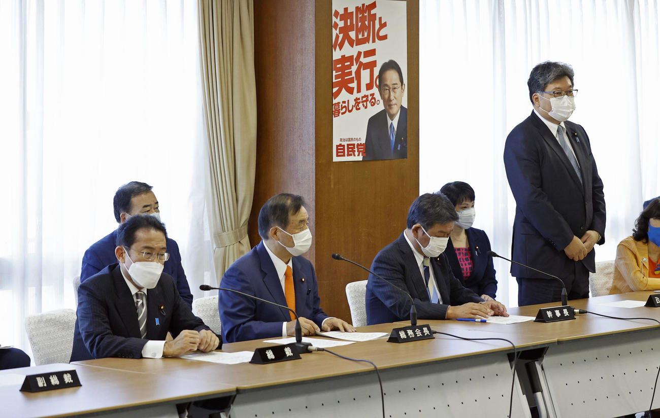 自民党の臨時総務会であいさつする萩生田政調会長（右端）、左端は岸田首相（共同）
