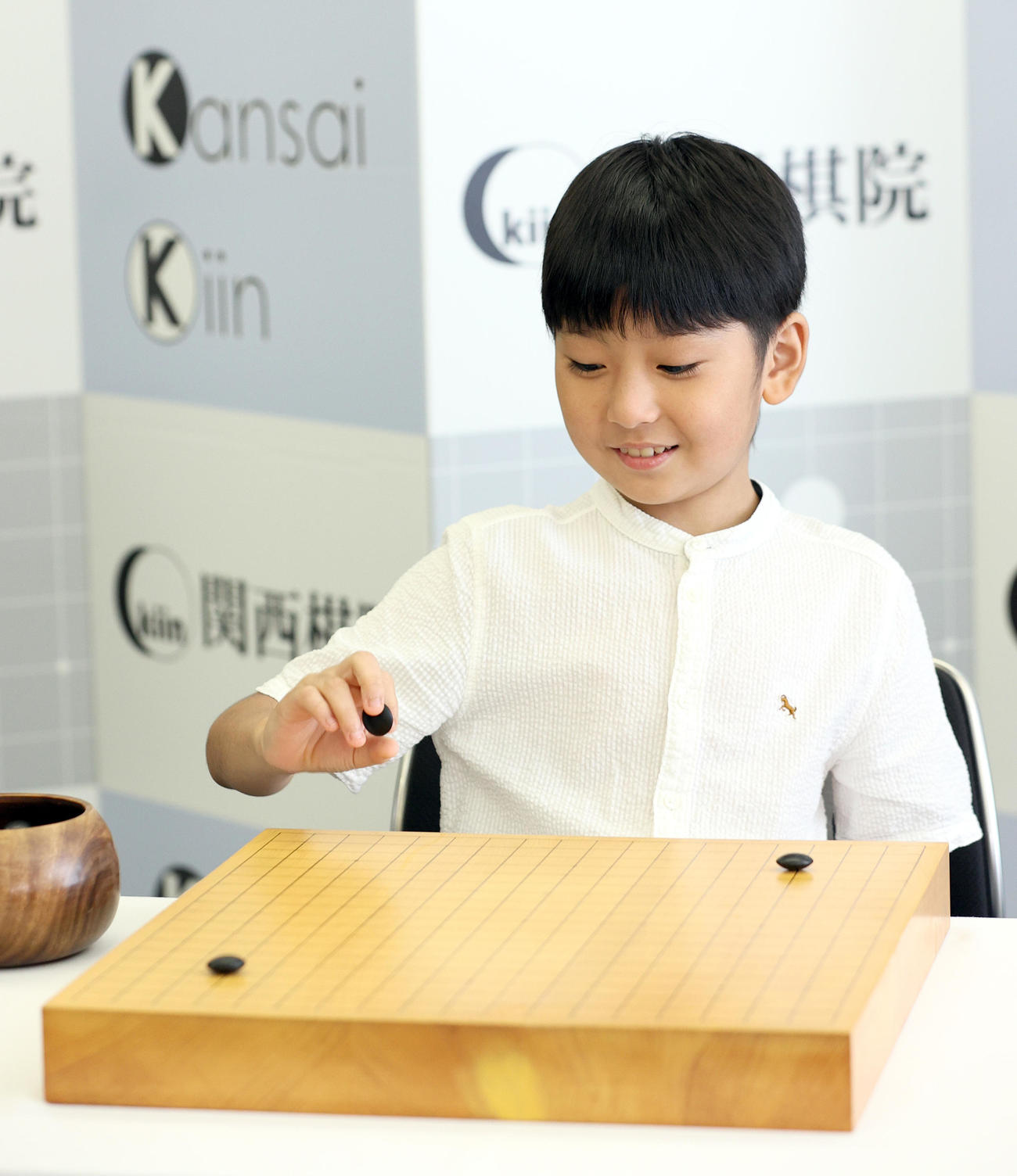 記者会見の後、碁盤と碁石を使っての撮影に応じた藤田怜央くん（撮影・上山淳一）