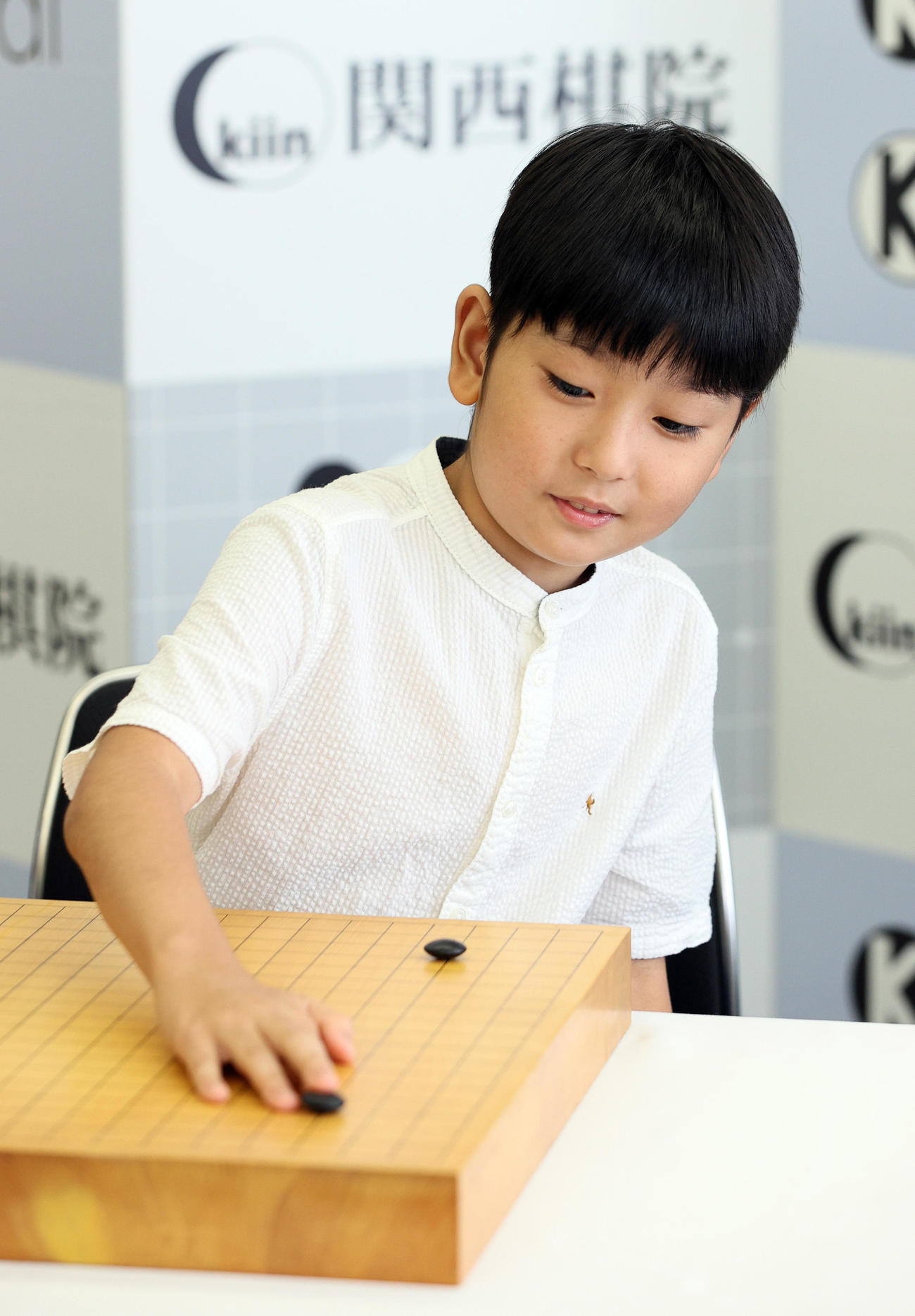 記者会見の後、碁盤と碁石を使っての撮影に応じた藤田怜央くん（撮影・上山淳一）