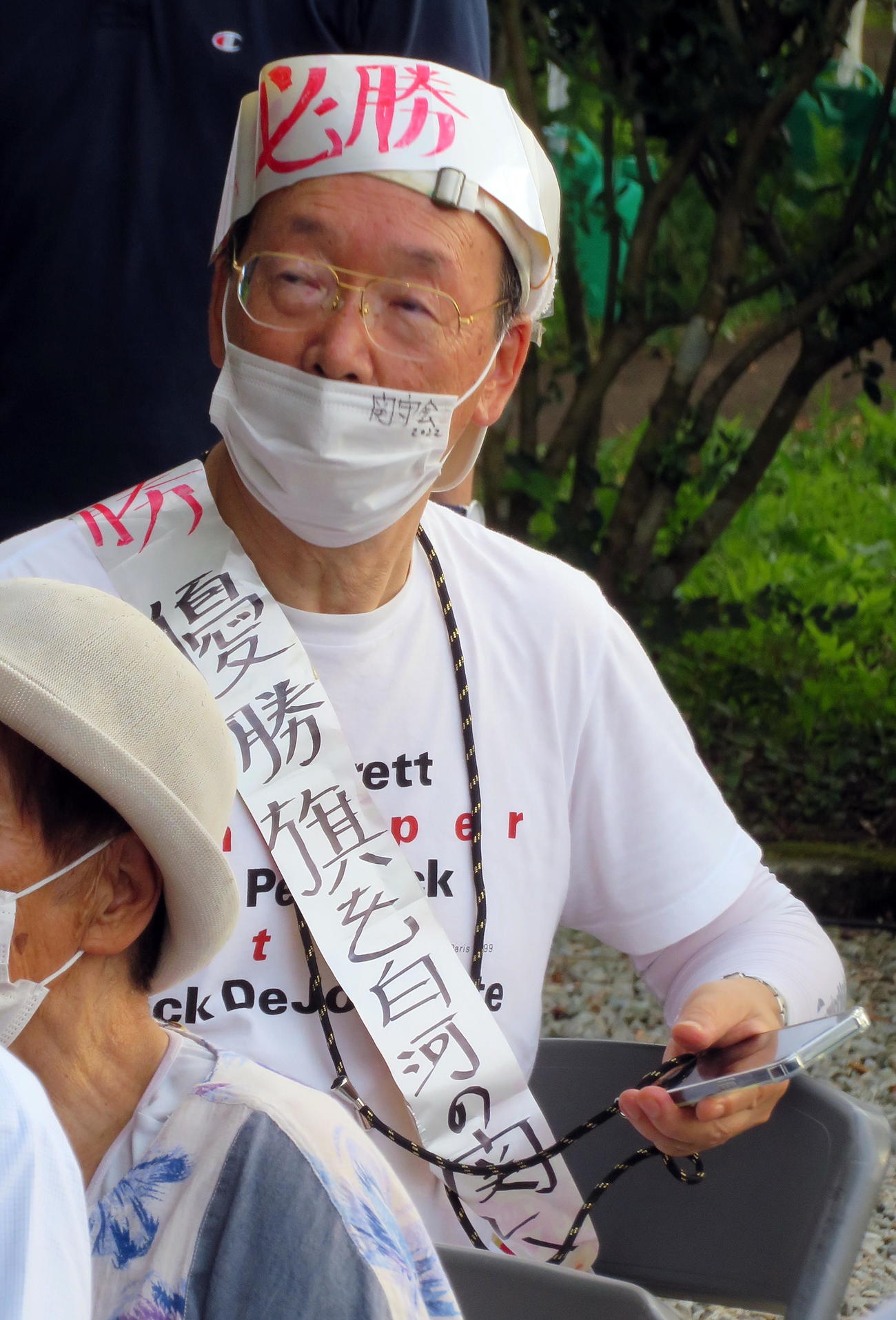 白河の関跡でのパブリックビューイングに「優勝旗を白河の関に　見せてくれ東北魂」と記したたすきをかけた参加者（撮影・鎌田直秀）