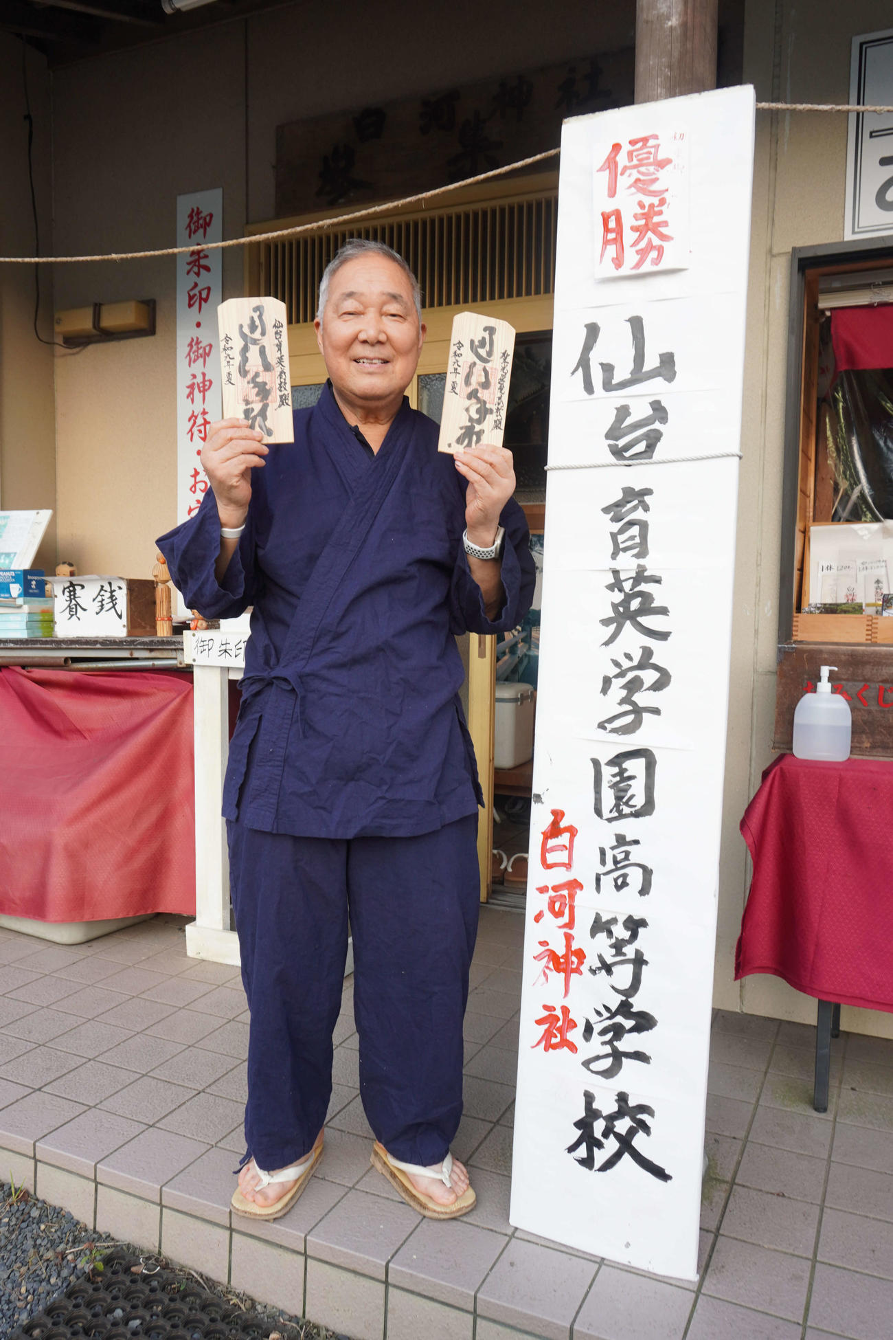 仙台育英などに贈った通行手形のサンプルを手に、笑顔を見せる白河神社の西田重和宮司（撮影・沢田直人）