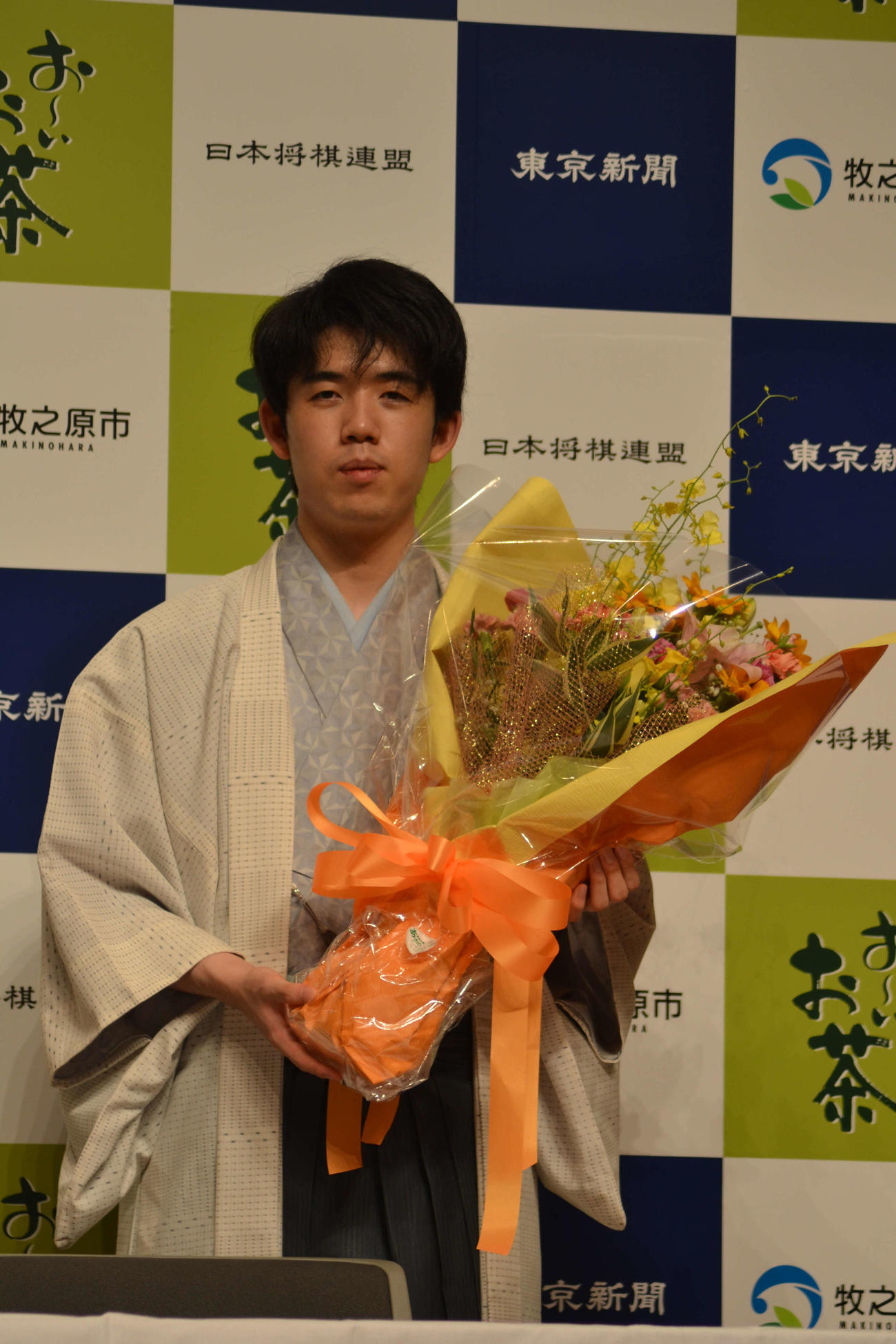 王位を防衛して記念の花束を手にする藤井聡太王位