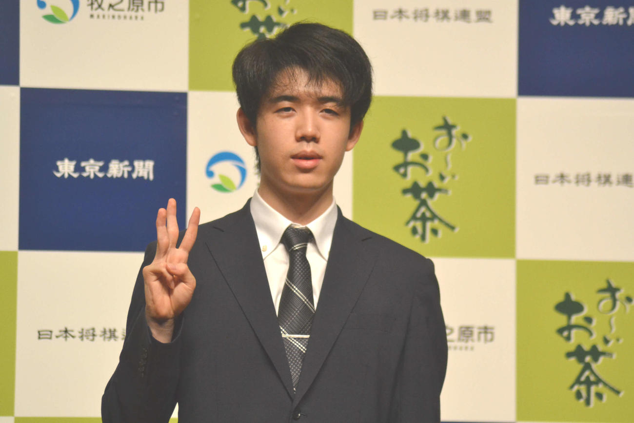 王位戦3連覇の一夜明け会見で「V3」を右手で表現する藤井聡太王位