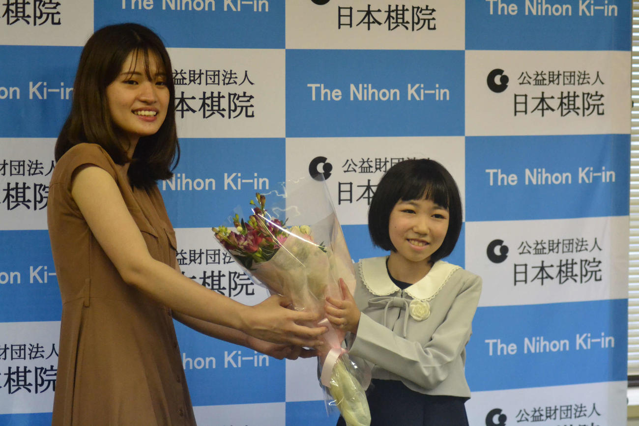 藤沢里菜女流本因坊（左）から花束を贈呈される柳原咲輝さん（右）