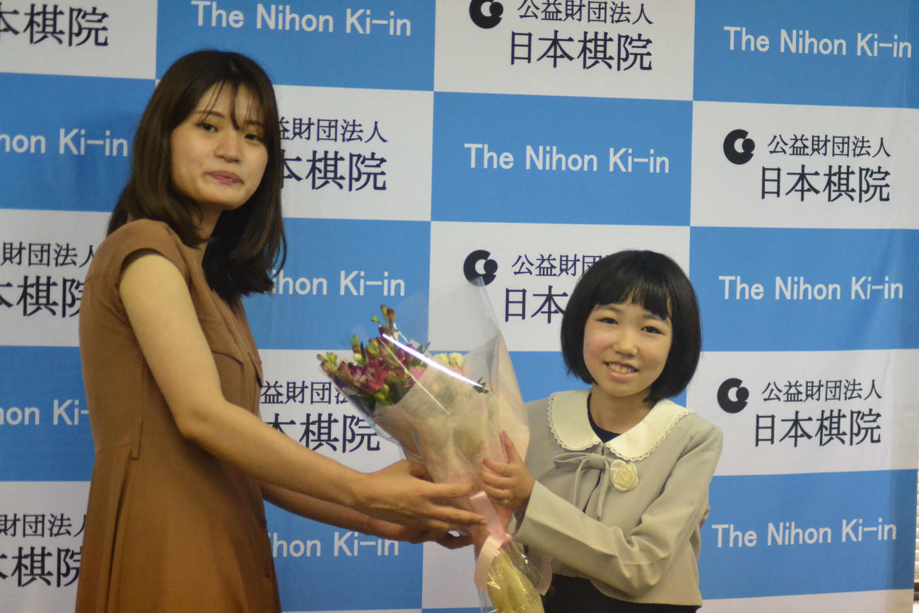 藤沢里菜女流本因坊（左）から花束を贈呈される柳原咲輝さん（右）