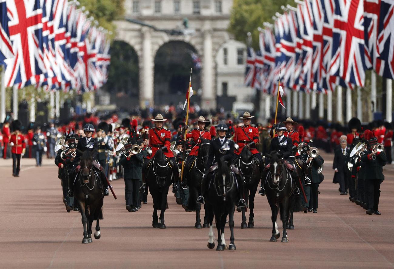 王立カナダ騎馬警察らに先導される様子（ロイター）
