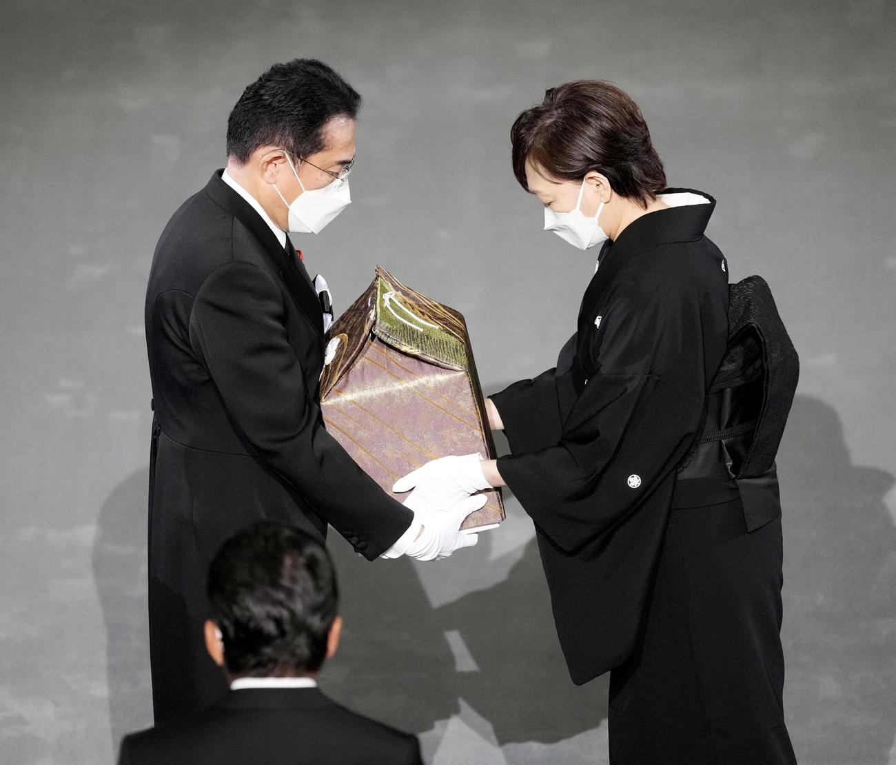 安倍元首相の国葬で、昭恵夫人（右）から遺骨を受け取る岸田首相＝27日午後2時5分（共同）