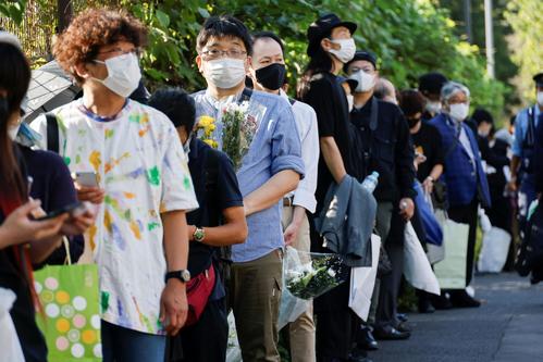 日本武道館付近で献花のために並ぶ人たち（ロイター）