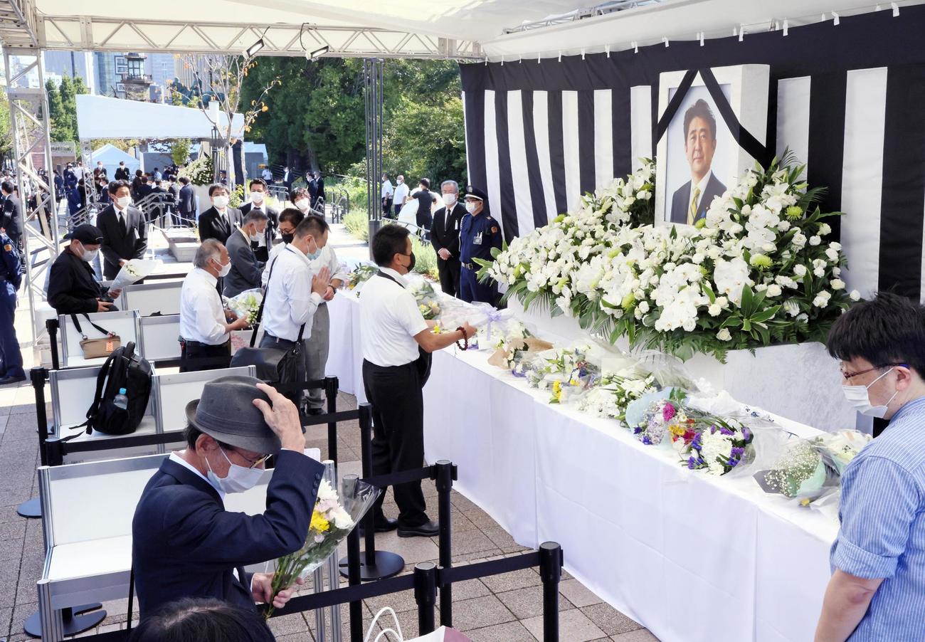 安倍元首相の国葬が行われる日本武道館近くに設けられた一般献花台に花を手向ける人たち（代表撮影）