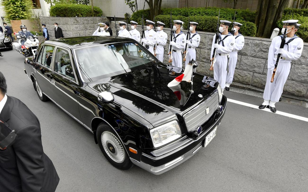 自宅を出て儀仗隊の前を通る、安倍元首相の遺骨を乗せた車＝27日午後1時26分（共同）