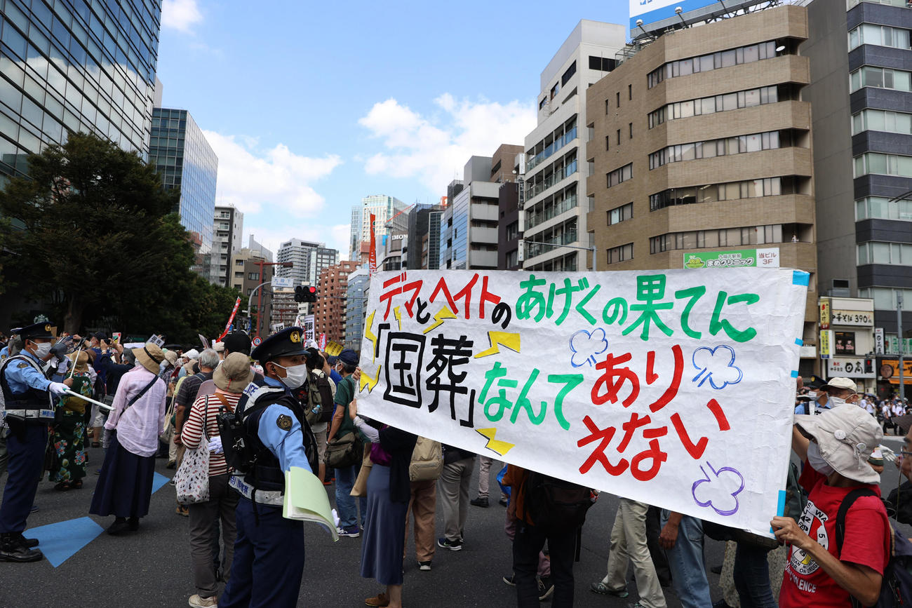 安倍晋三元首相の国葬が行われる日本武道館近くで警察官とごった返す反対デモ行進を行う人々＝午後0時30分すぎ（撮影・狩俣裕三）