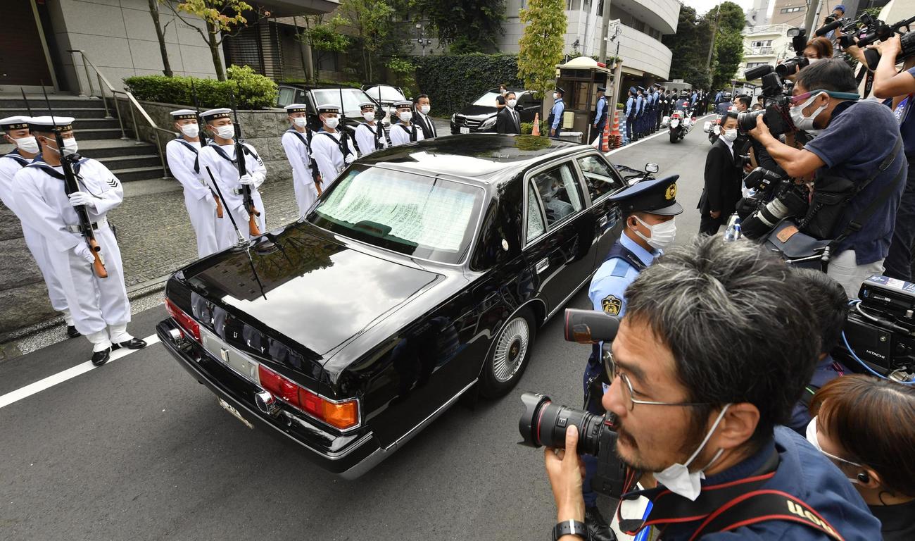 自宅を出て儀仗隊の前を通る、安倍元首相の遺骨を乗せた車＝27日午後1時26分（共同）
