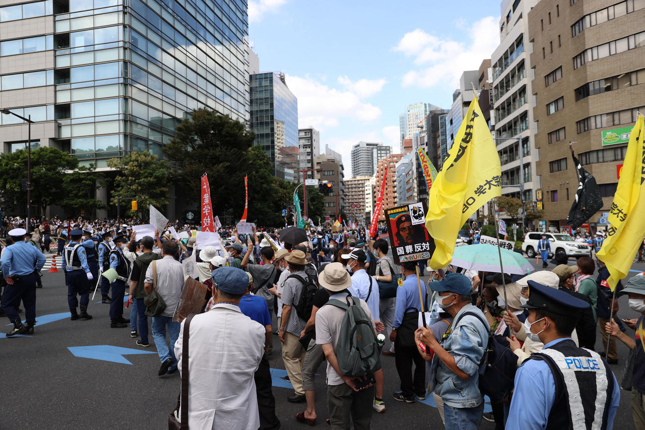 安倍晋三元首相の国葬が行われる日本武道館近くで警察官とごった返す反対デモ行進を行う人々＝午後12時30分すぎ（撮影・狩俣裕三）