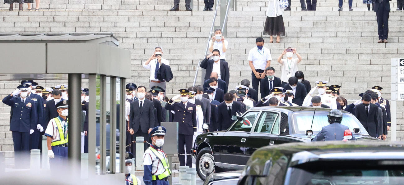 国葬が行われる日本武道館に向かう前、防衛省を経由する安倍晋三元首相の遺骨を載せた車に敬礼する防衛省の幹部たち（撮影・狩俣裕三）