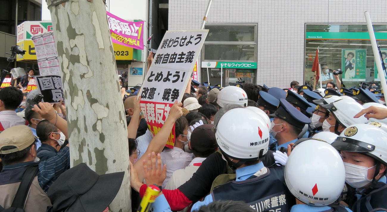 国葬反対を訴えるデモ参加者ら（左）の行く手を阻む警察官たち（撮影・鎌田直秀）