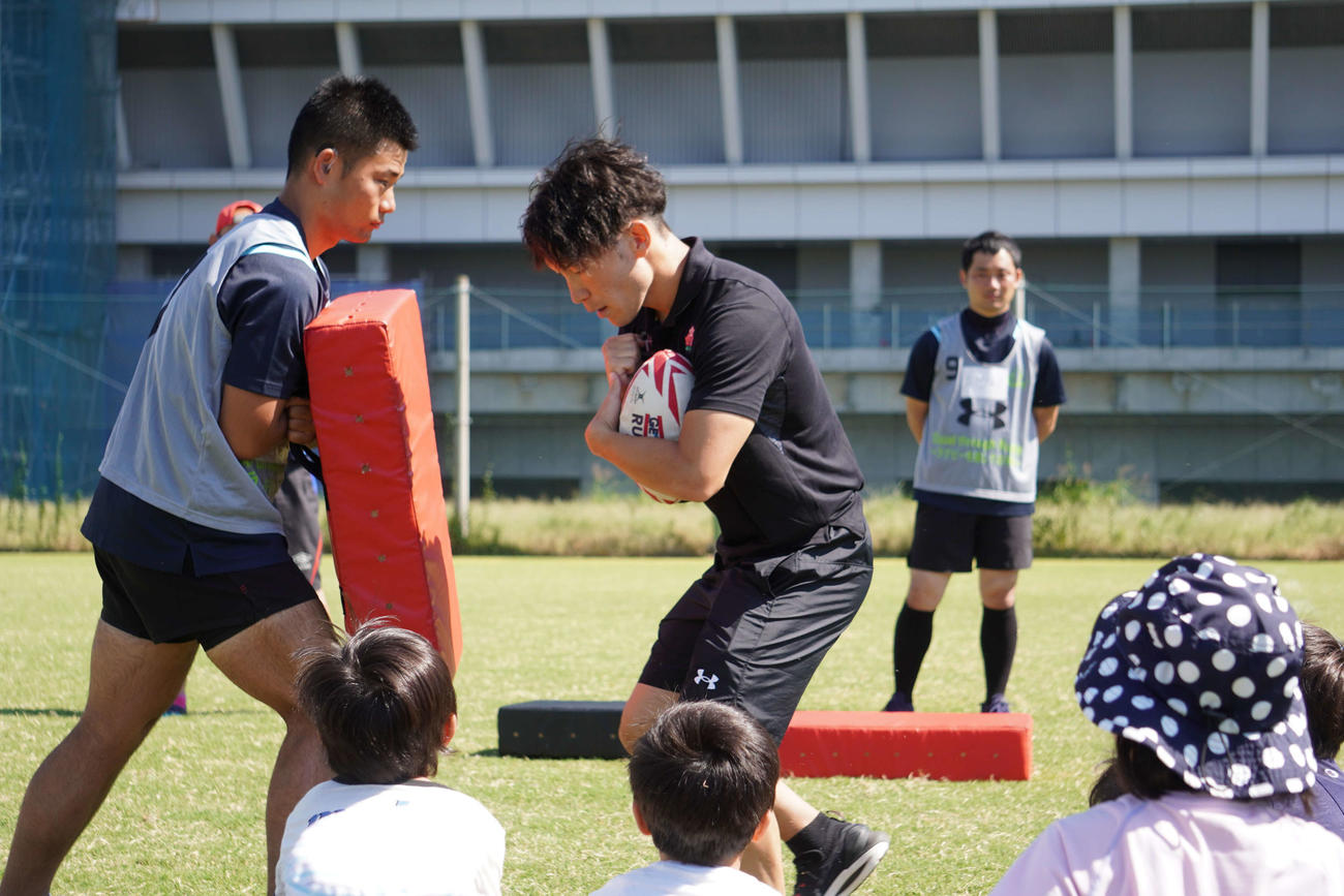 「手話で楽しむ！みんなでラグビー体験会」で子どもたちに手本を披露する大塚貴之さん（撮影・沢田直人）