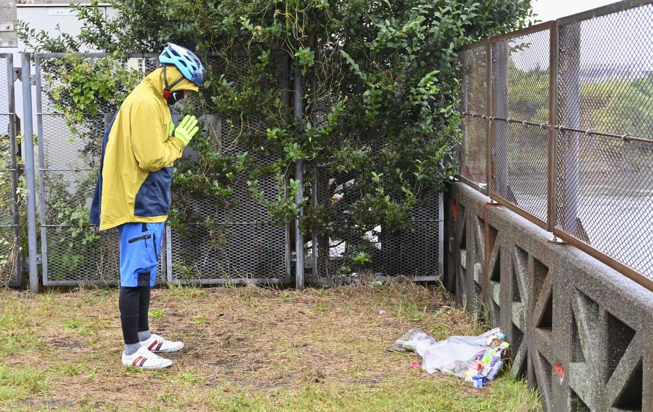 行方不明になっていた南朝芽さんの遺体が見つかった旧江戸川に向かって手を合わせる男性（共同）
