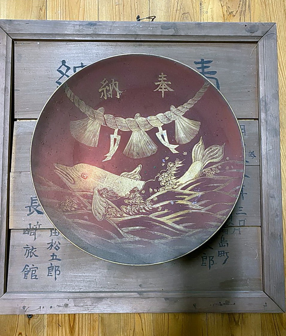 今月上旬、須須神社で見つかった明治時代に奉納されたとみられるイルカが描かれた盃（出村正幸さん提供）