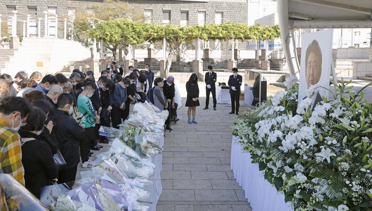 安倍元首相の遺影の前で黙とうする人たち＝15日午後2時11分、山口県下関市（共同）