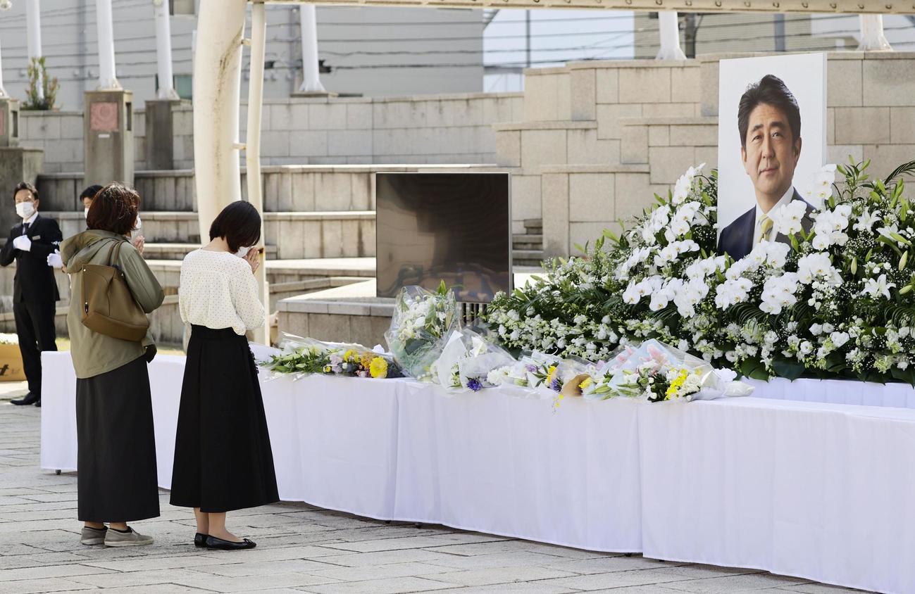 安倍元首相の県民葬会場を訪れ、遺影に手を合わせる人たち＝15日午前11時22分、山口県下関市（共同）