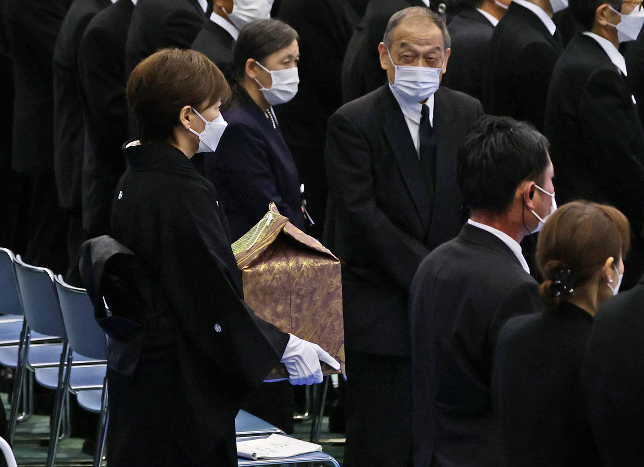 安倍元首相の遺骨を手に、県民葬の会場へ入る昭恵夫人（左）＝15日午後2時4分、山口県下関市（共同）