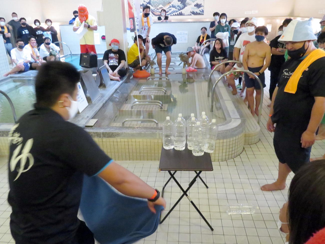 テーブルペットボトル落としの技術競技を見つめる参加者たち（撮影・鎌田直秀）