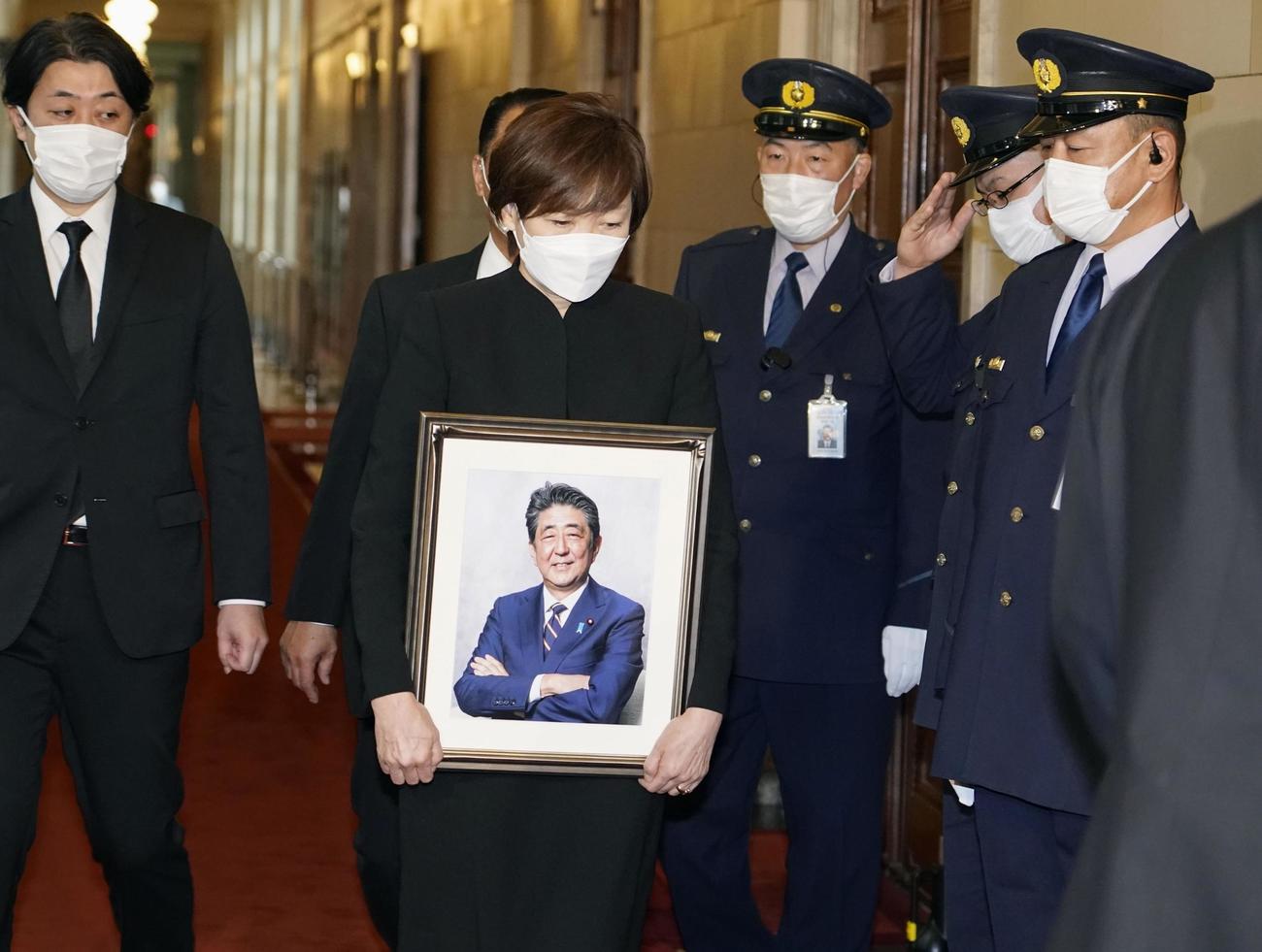 遺影を手に、安倍元首相の追悼演説が行われる衆院本会議に向かう安倍昭恵さん（共同）