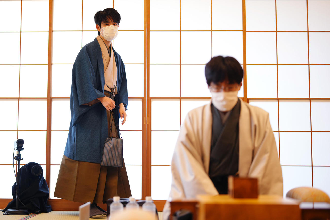 対局室に入る藤井聡太竜王（左）と再開を待つ広瀬章人八段（代表撮影）
