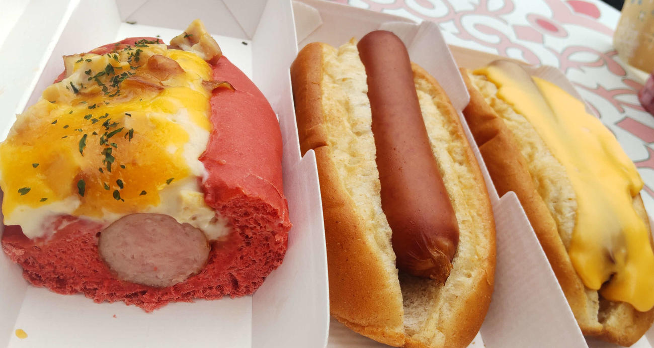 左側の断面はチキンとBBQソースのグラタンドッグ、中央が普通のホットドッグ、右はチーズドッグ（撮影・寺沢卓）