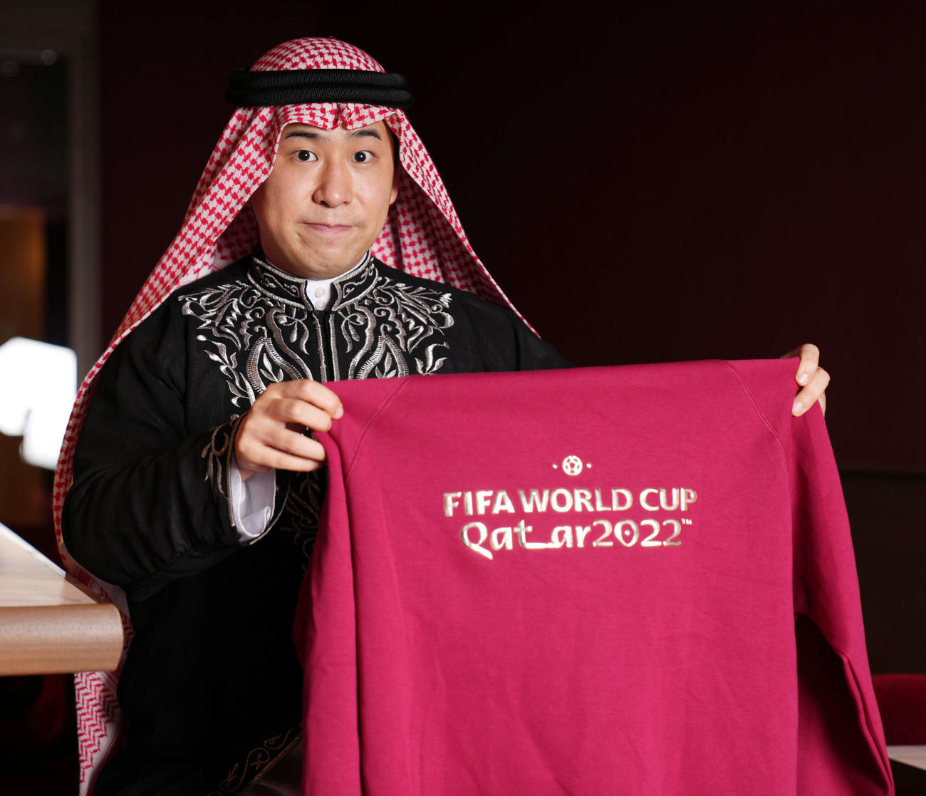 カタールW杯の公式グッズを手にする鷹鳥屋明氏