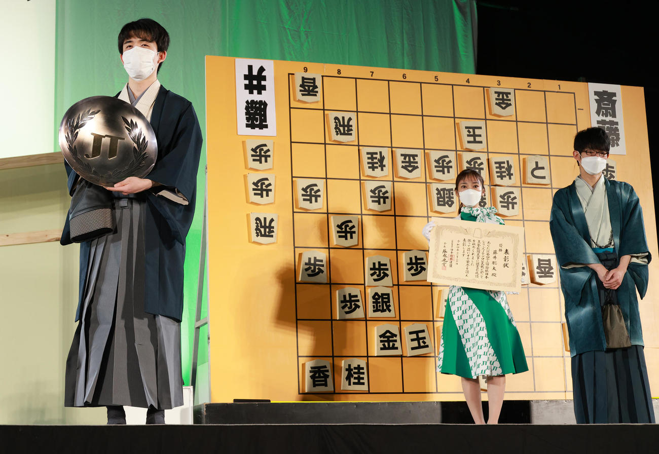 2022年度将棋日本シリーズを制しJT杯を手にする藤井聡太竜王。右は斎藤慎太郎八段（撮影・中島郁夫）