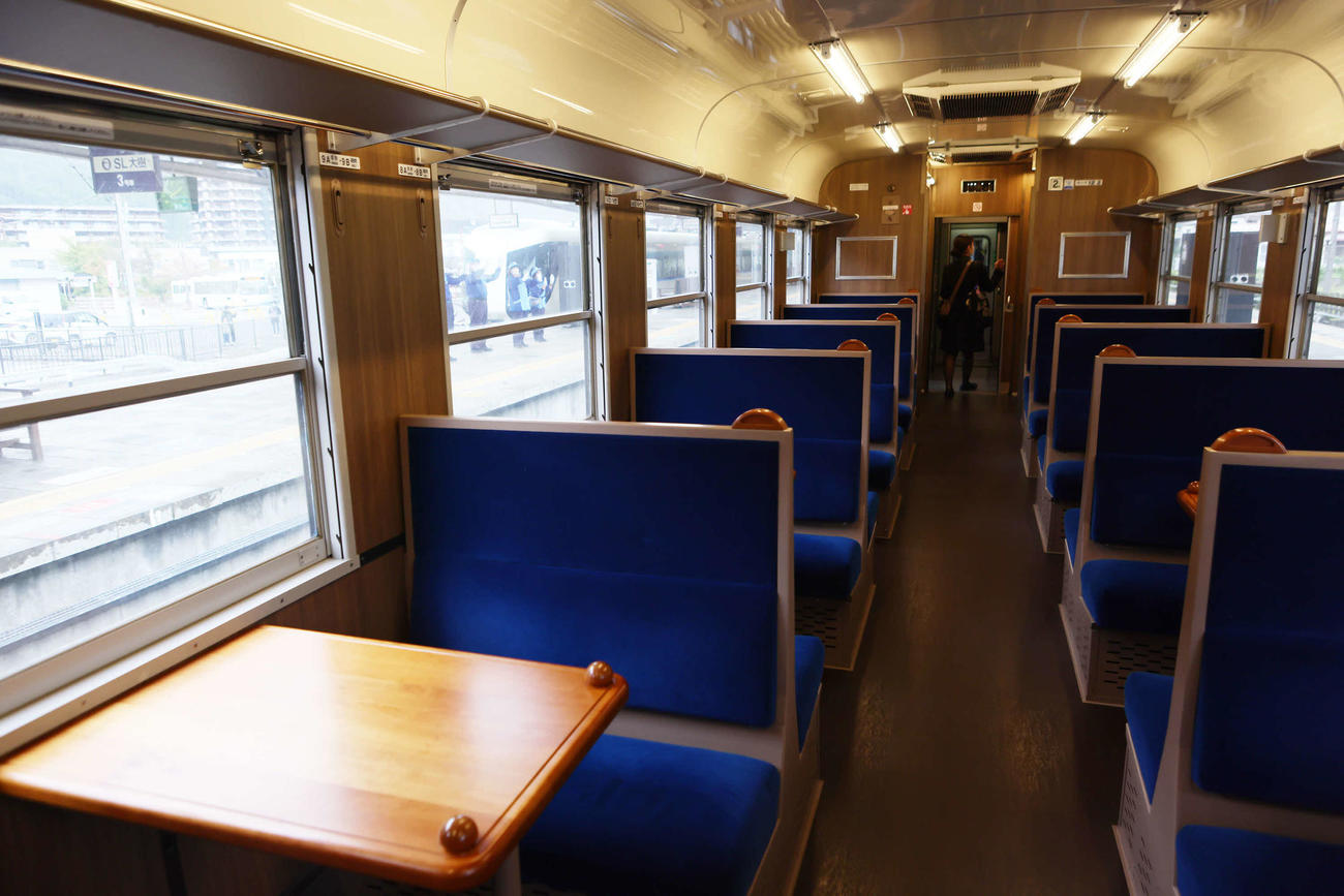 東武鉄道のSL大樹の車内。車窓にはSLに向かって手を振る人びとが見える（撮影・足立雅史）
