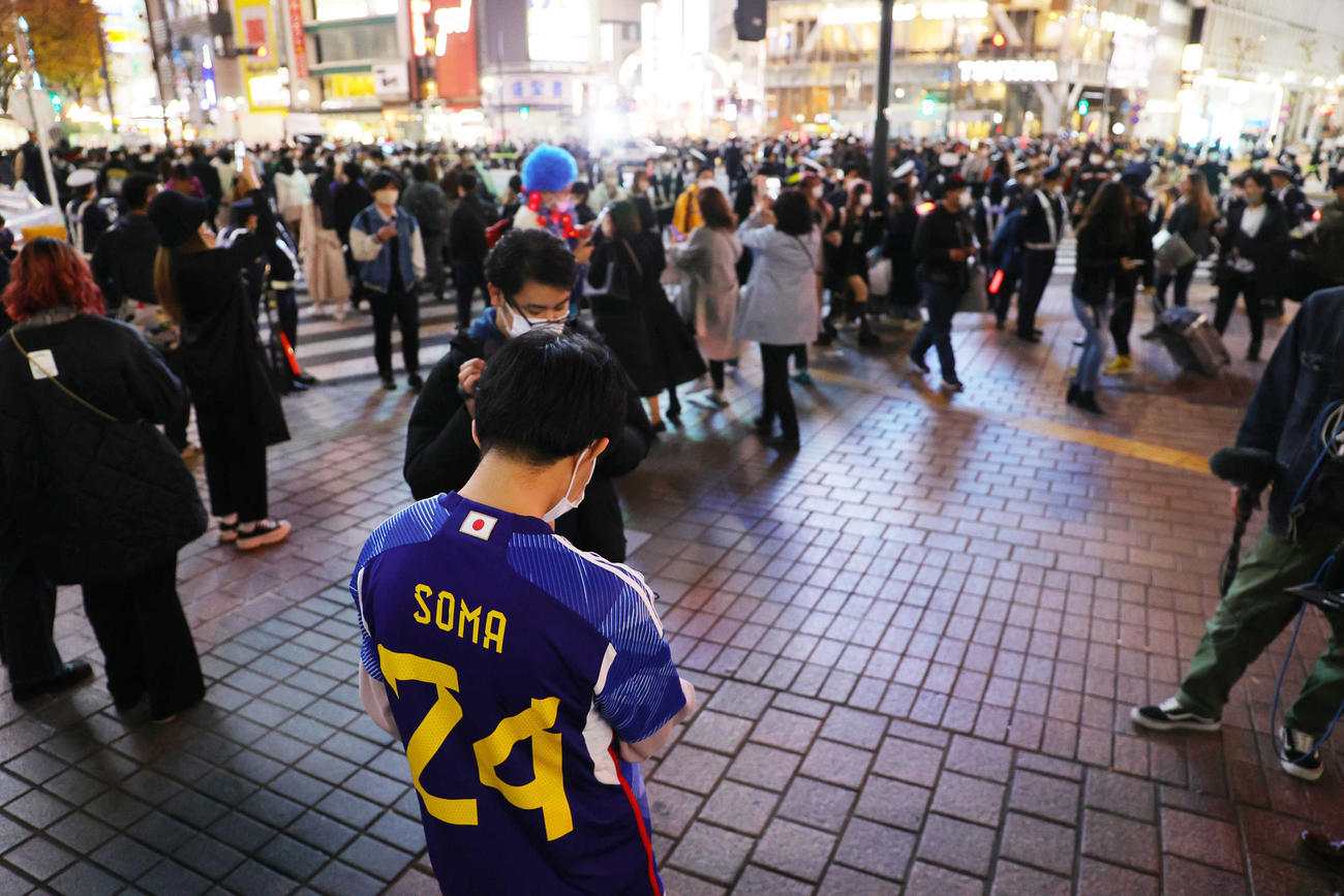 W杯の日本対コスタリカ戦が行われる時間に、多くの人でごった返す渋谷のスクランブル交差点。手前はスマホで試合経過を確認する日本サポーター（撮影・野上伸悟）
