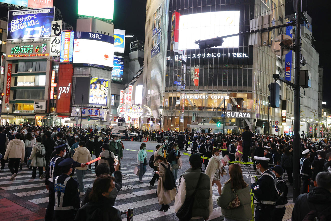渋谷のスクランブル交差点では多くの人でごった返す中、W杯で日本がコスタリカに敗れたニュースが流れる＝27日午後8時59分（撮影・野上伸悟）