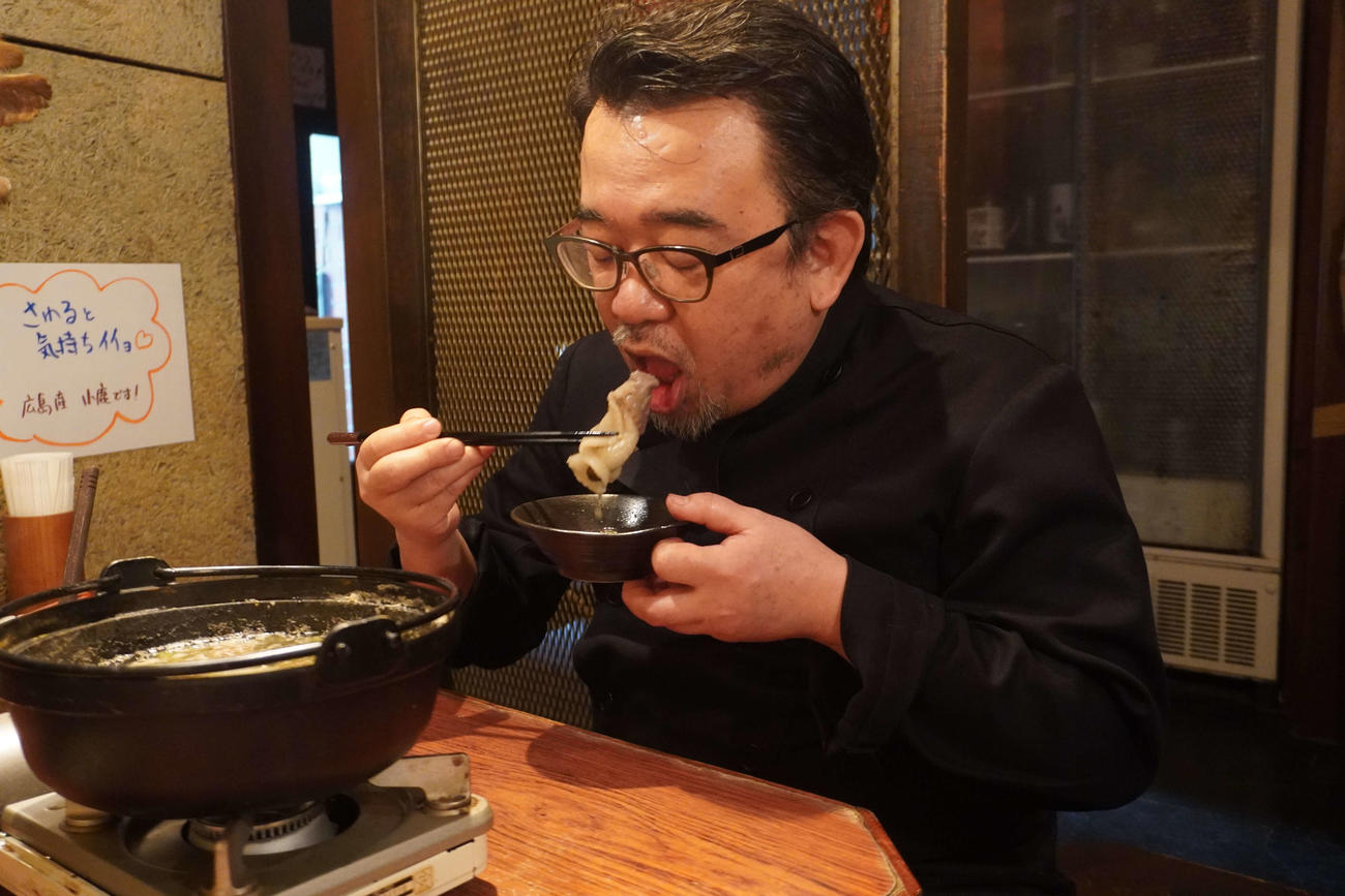 「山の主」のロースを食べる林育夫店長（撮影・沢田直人）