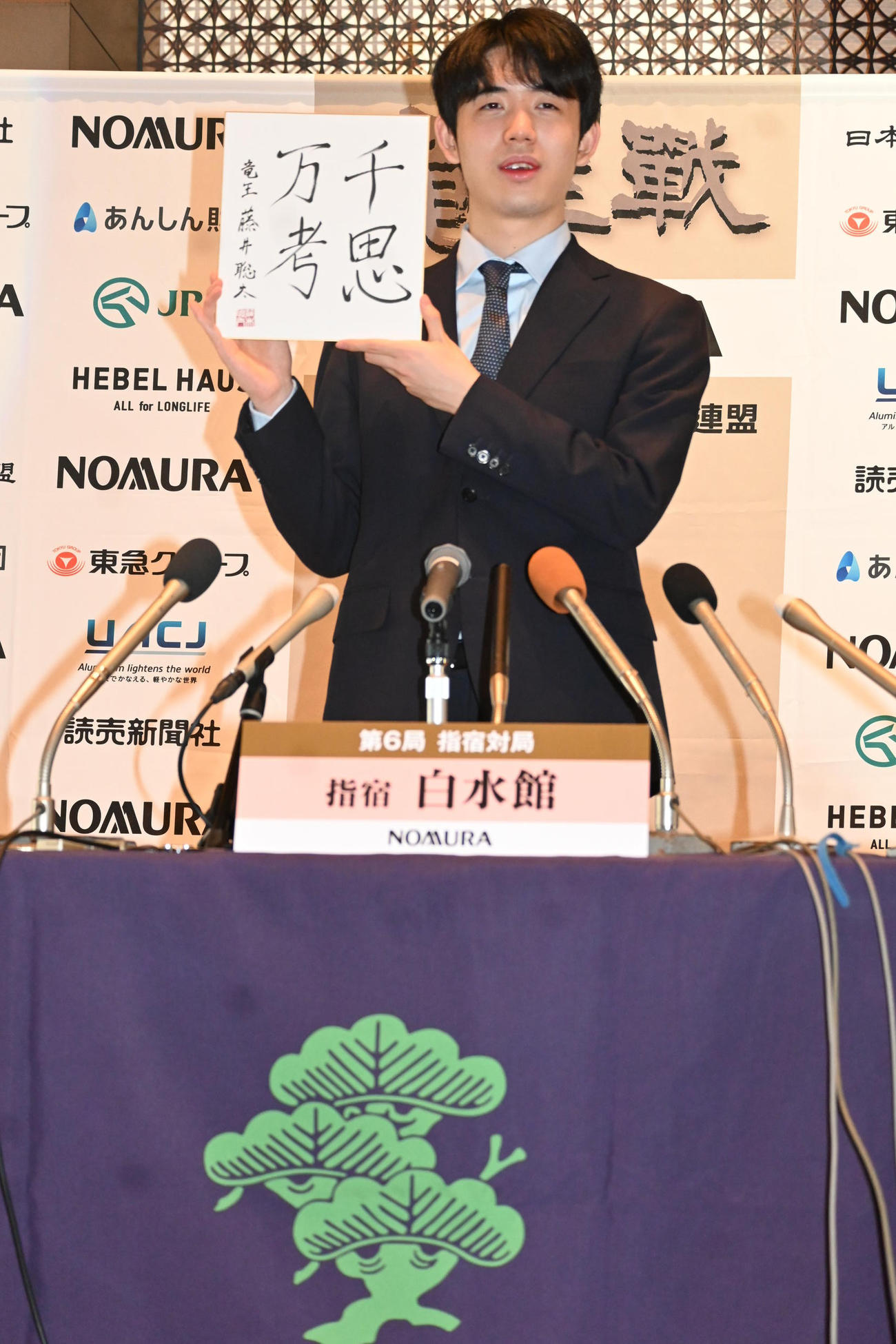 竜王初防衛の一夜明け会見で「千思万考」の色紙を披露する藤井聡太竜王（撮影・松浦隆司）