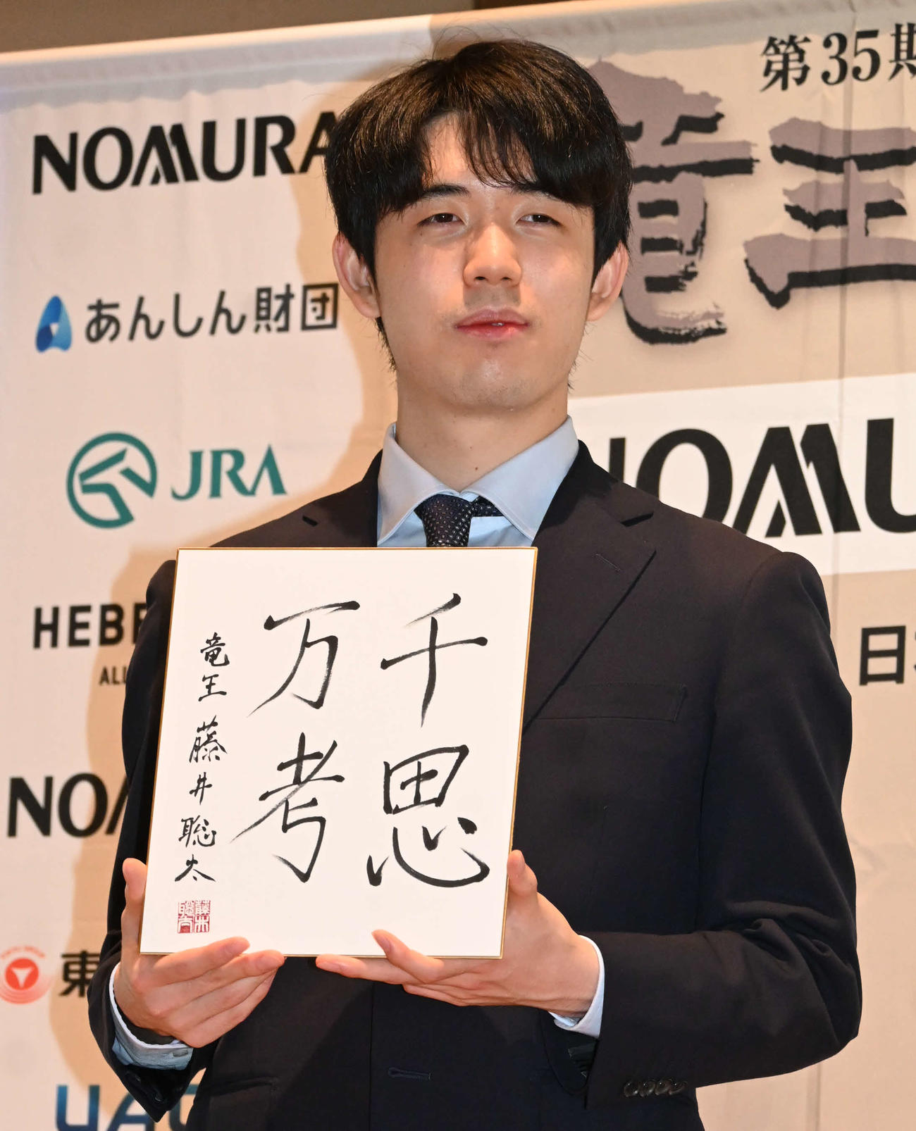 竜王初防衛の一夜明け会見で「千思万考」の色紙を披露する藤井聡太竜王（撮影・松浦隆司）