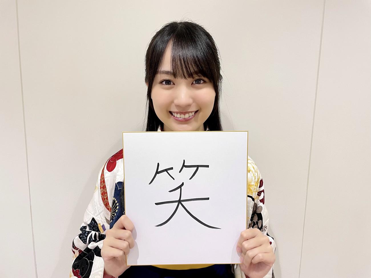 ドラマ「最初はパー」の衣装で今年の漢字「笑」と書いた色紙を持ち笑顔を見せる乃木坂46賀喜遥香