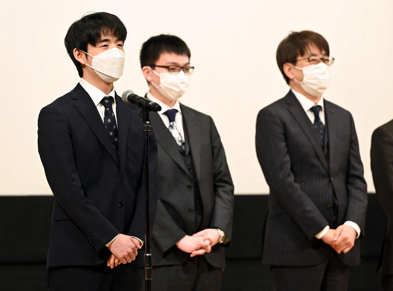開会式であいさつをする西軍の藤井竜王。後方右から東軍の羽生九段、同じく永瀬王座（撮影・たえ見朱実）