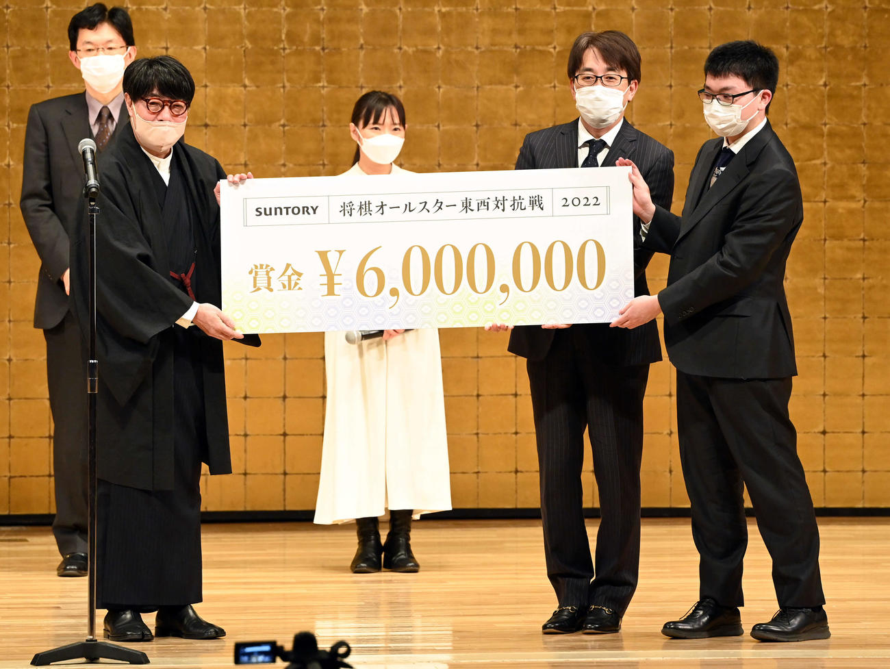 接戦の末、優勝を飾った東軍。代表して賞金受け取る永瀬王座（右）と羽生九段（撮影・たえ見朱実）