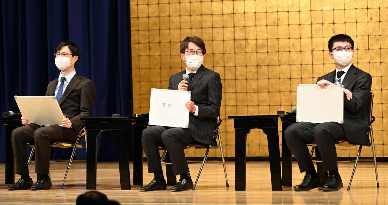 トークショーに登壇した羽生善治九段（中央）は「2023年に挑戦したいもの」を聞かれボードに記す。左から横山七段、1人おいて永瀬王座（撮影・たえ見朱実）